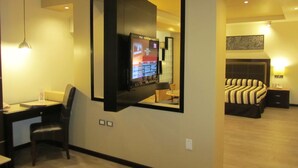 A hotel room with a desk, chair, television, bed, and a mirror. - Hotel Colonial (Teziutlan)