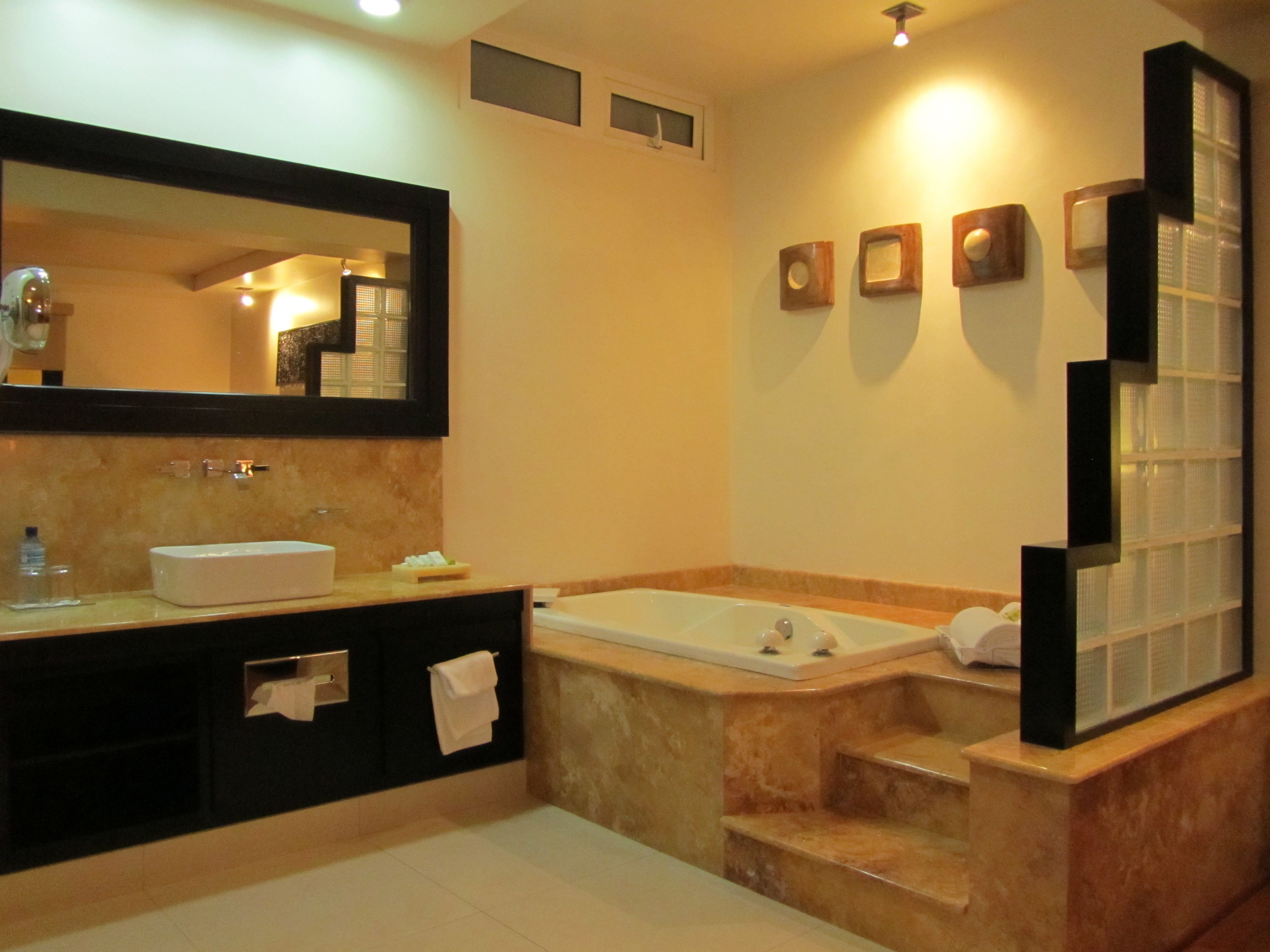 A modern bathroom with a large mirror, a bathtub, and a vanity with a sink and towel rack.