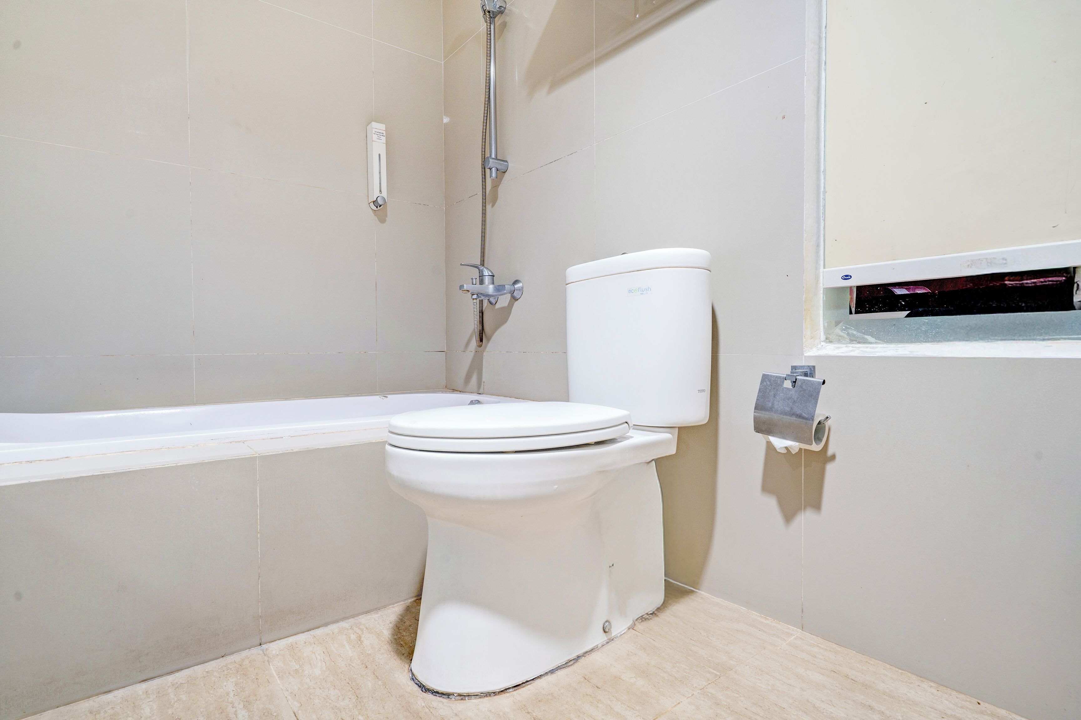 A bathroom with a toilet, a bathtub, and a shower.