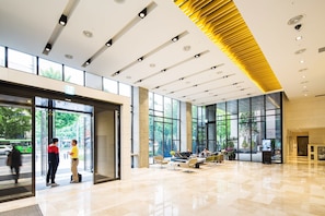 A spacious lobby with a high ceiling, large windows, and a modern design. - Hotel Denim (Seoul)