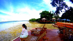 A wooden deck with seating and a view of the sea. - Scuba Tiger Semporna Holiday Resort (Semporna)