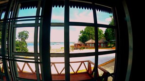 A view through a window with a wooden deck and a beach in the background. - Scuba Tiger Semporna Holiday Resort (Semporna)