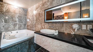 A modern bathroom with a freestanding bathtub, a vanity with a sink, and a large mirror.