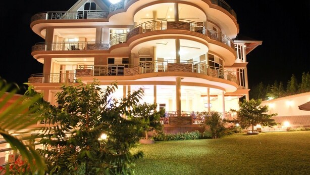 A multi-story building with balconies and a well-lit exterior. - New Agena Hotel (Bujumbura)