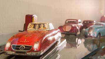 Une collection de voitures jouets anciennes, disposées sur une surface réfléchissante.