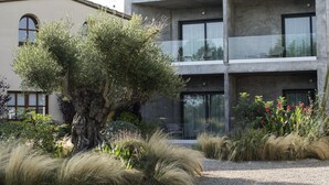 Un edificio moderno con un balcón y un árbol en primer plano.