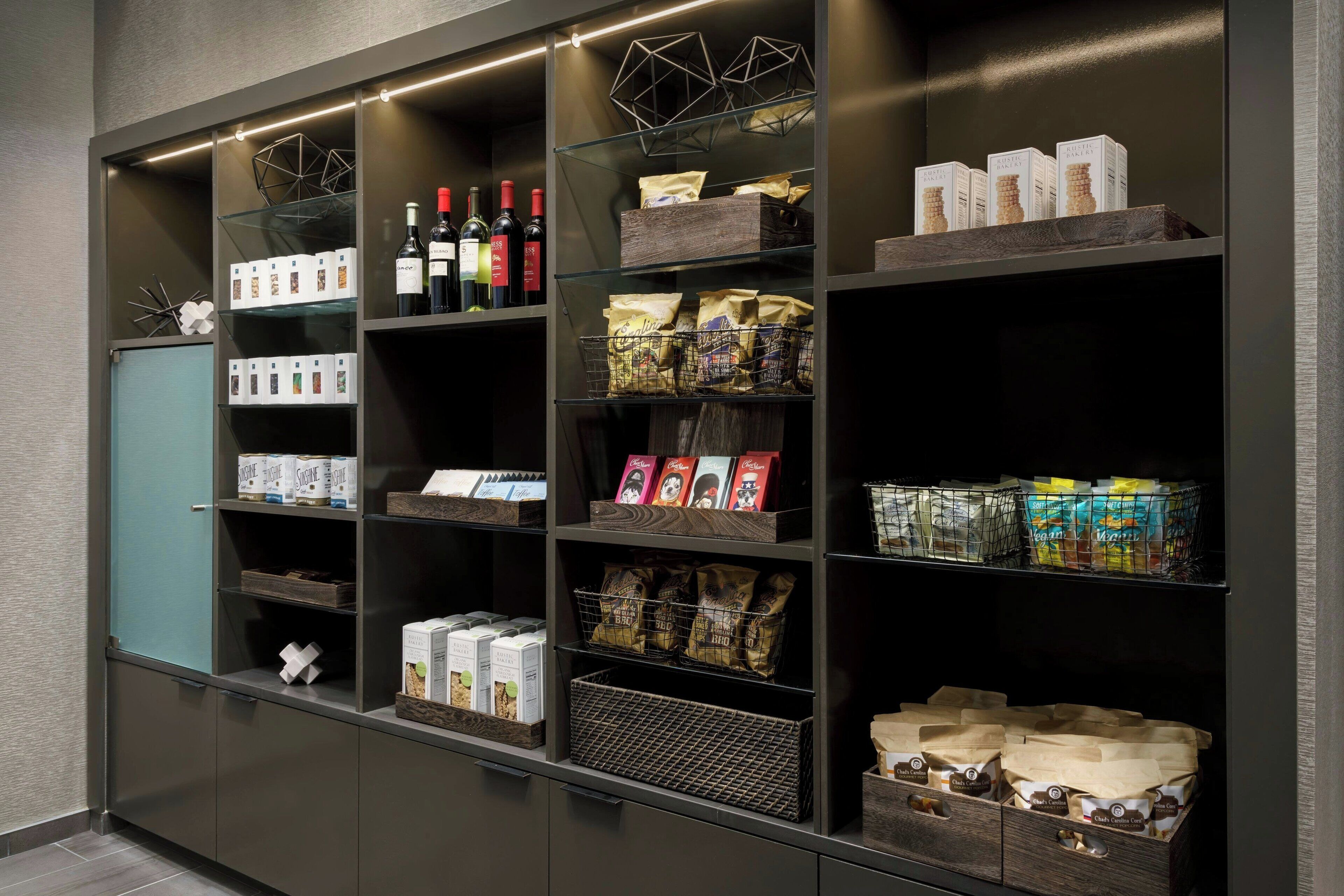 Um espaço de armazenamento bem organizado, com prateleiras contendo diversos itens como garrafas de vinho, café e petiscos.