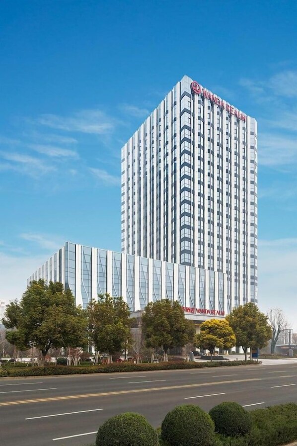 Un edificio alto y moderno con un letrero visible que dice 'Wanda Realm'.