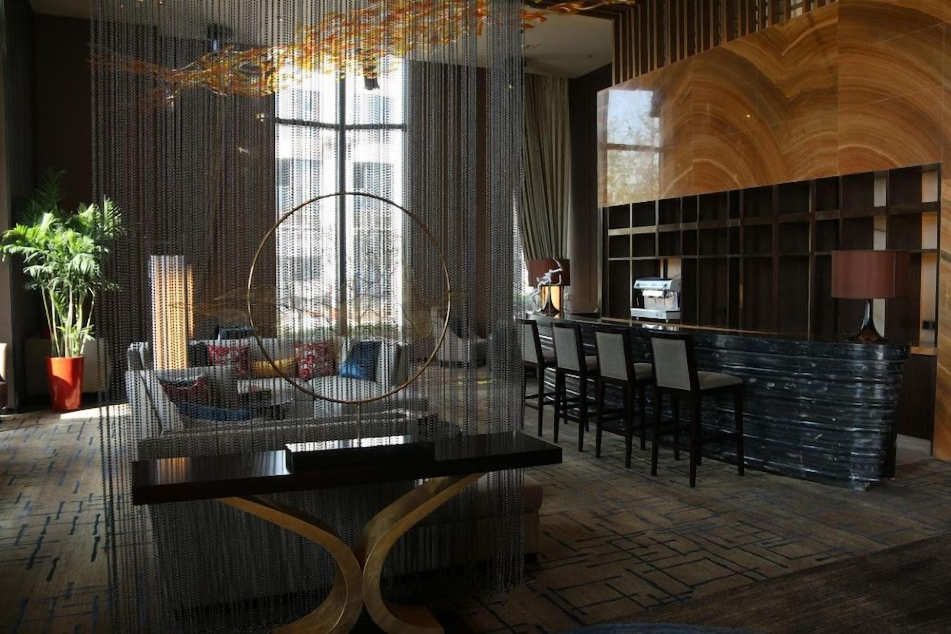 A modern interior with a bar area, seating, and a large window.