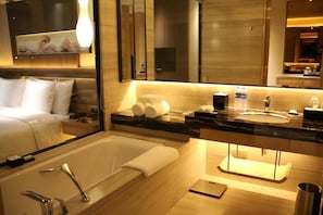 A modern bathroom with a bathtub, a large mirror, and a vanity with a sink. - Wanda Realm Bengbu (Bengbu)