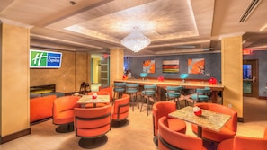 A Holiday Inn Express lobby with a bar area, seating, and a fireplace. - Holiday Inn Express Wichita South by IHG (Wichita)