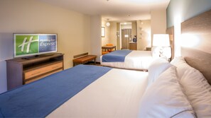 A hotel room with two beds, a television displaying 'Holiday Inn Express', a desk with a chair, and a bathroom visible in the background.