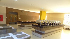 Un'area buffet con diverse postazioni self-service, posti a sedere e una reception.
