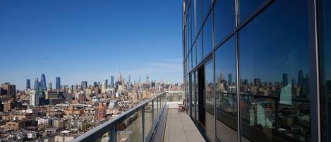 A high-rise building with a glass facade overlooking a cityscape.