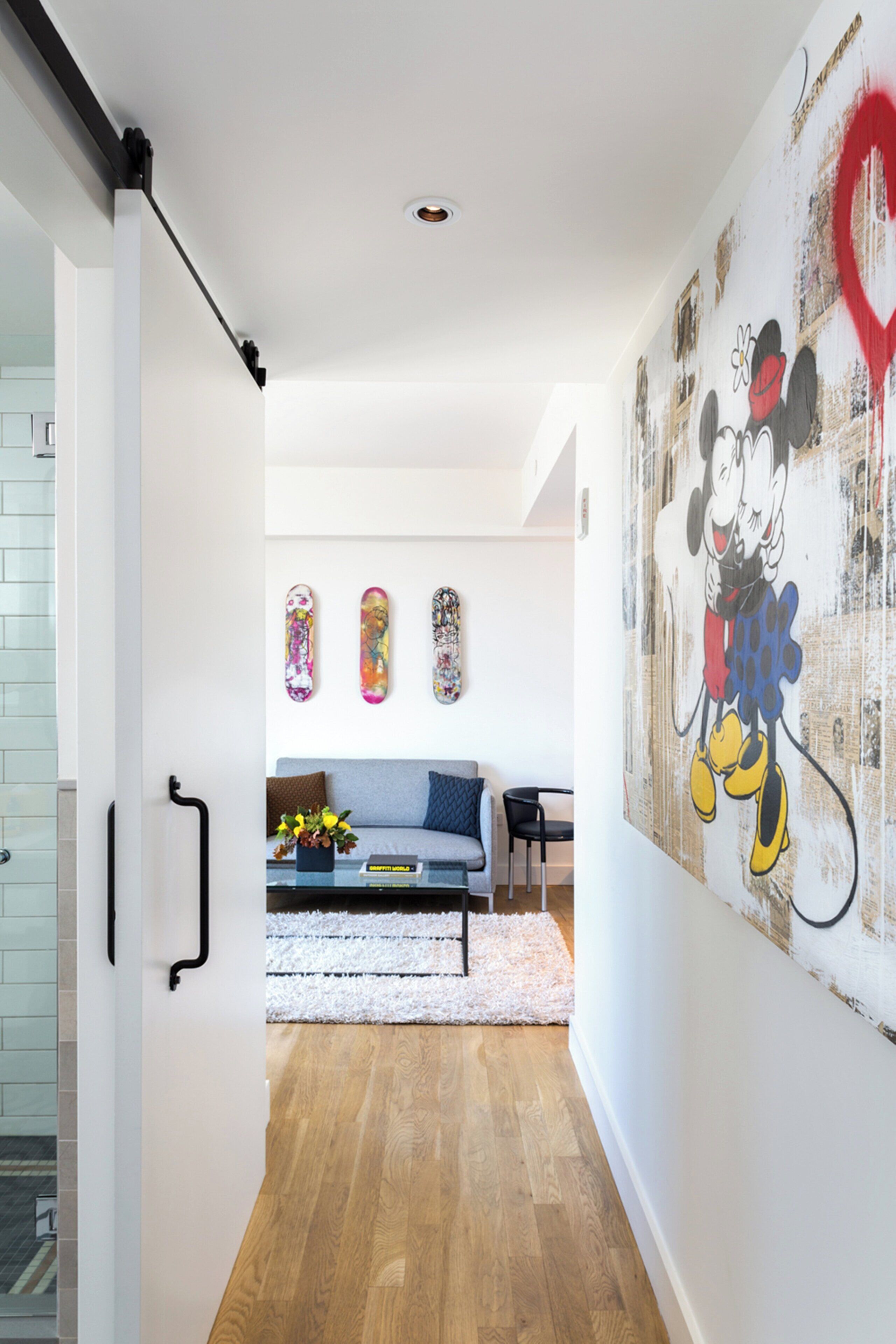 A modern living room with a large wall mural, a sofa, and a coffee table.