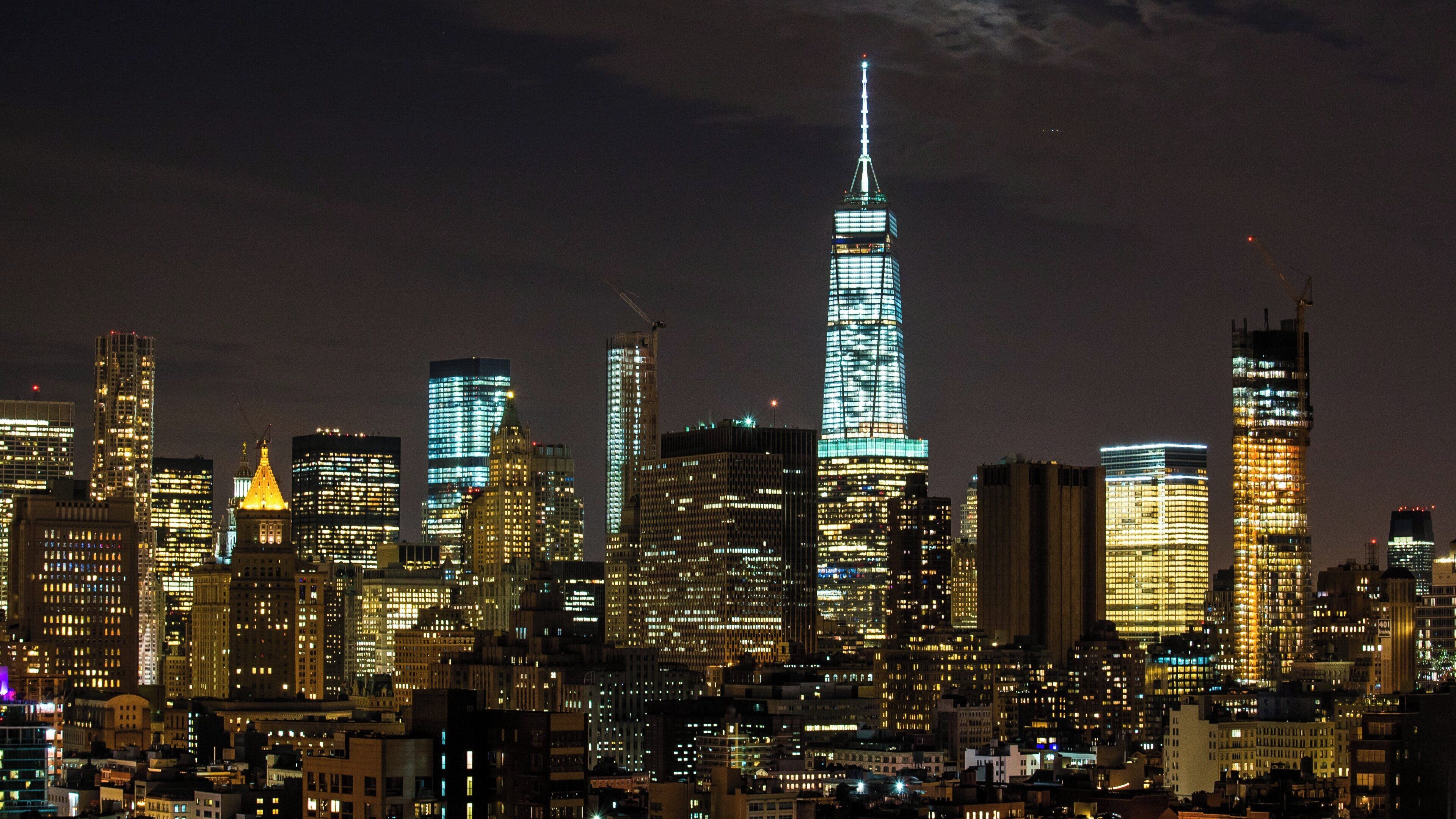 A nighttime cityscape with a prominent skyscraper.