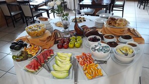 A buffet table with various fruits, pastries, and desserts. - Altos Ushuaia Hotel & Resto (Ushuaia)