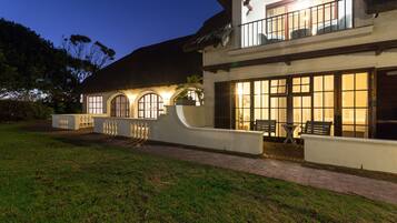 Vista frontal de la propiedad por la tarde o noche