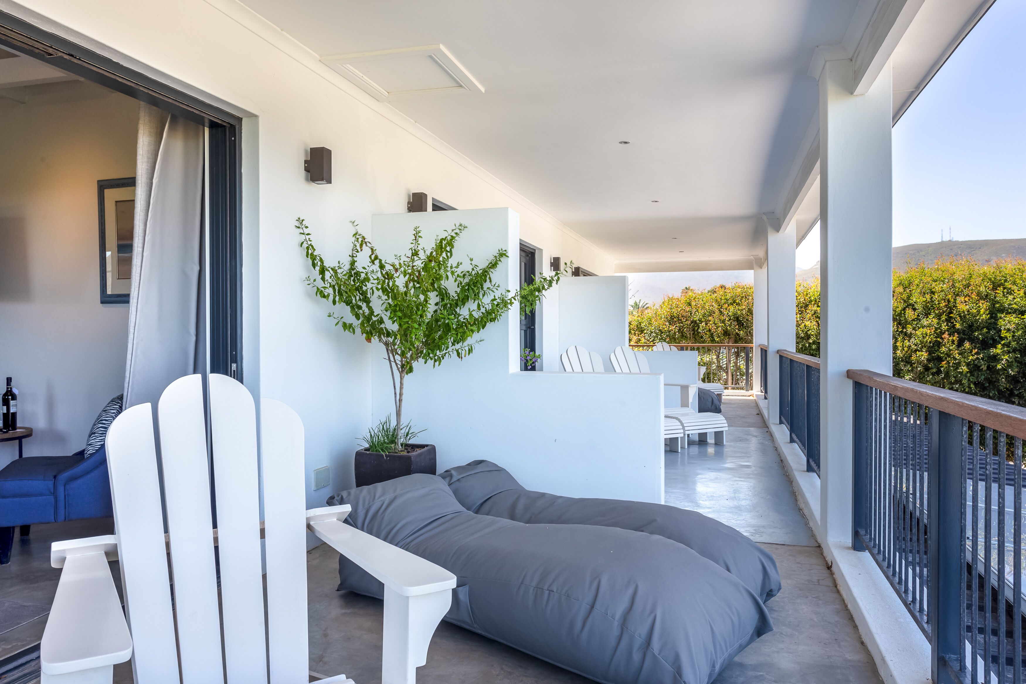 A modern balcony with a white sofa, a dining table, and chairs.