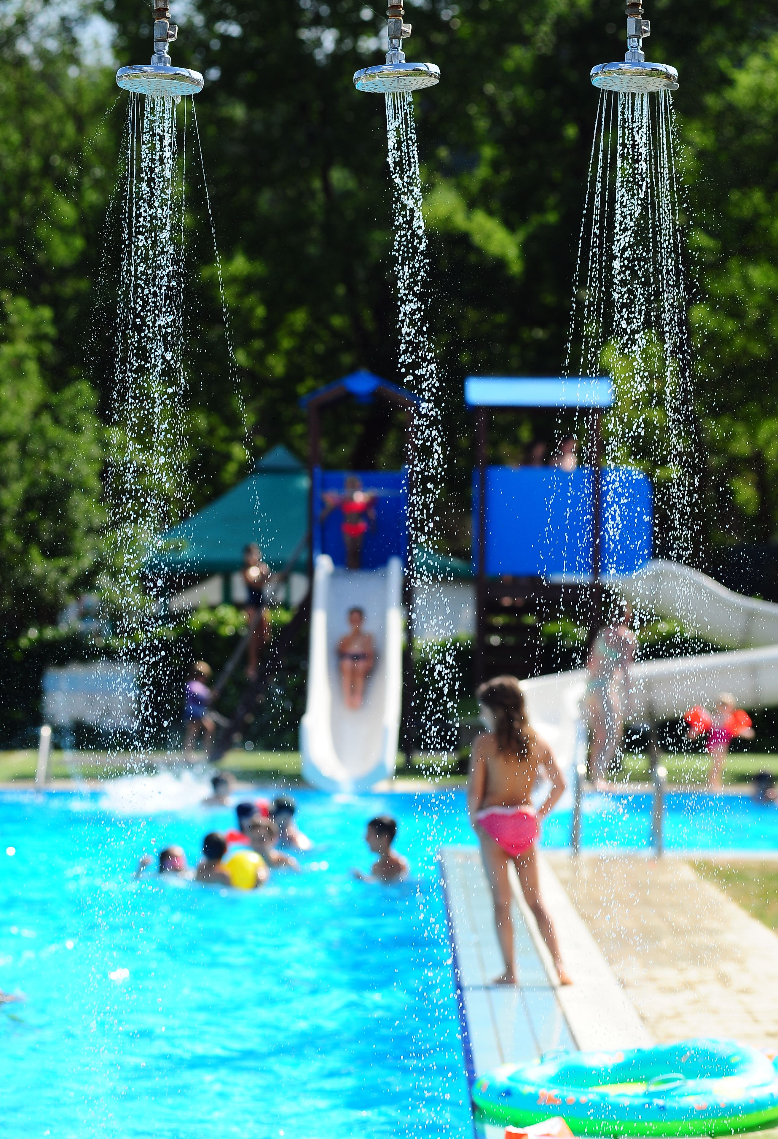 A swimming pool with multiple water features, including a slide and water jets.