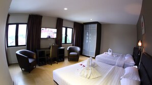 A hotel room with two beds, a desk, two chairs, a TV, and a wardrobe. - GL Hotel (Kluang)