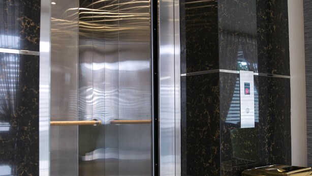 An elevator with a metallic interior and a control panel on the wall. - GL Hotel (Kluang)
