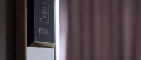 A modern door with a card reader and a sleek handle, likely part of a hotel or office building.