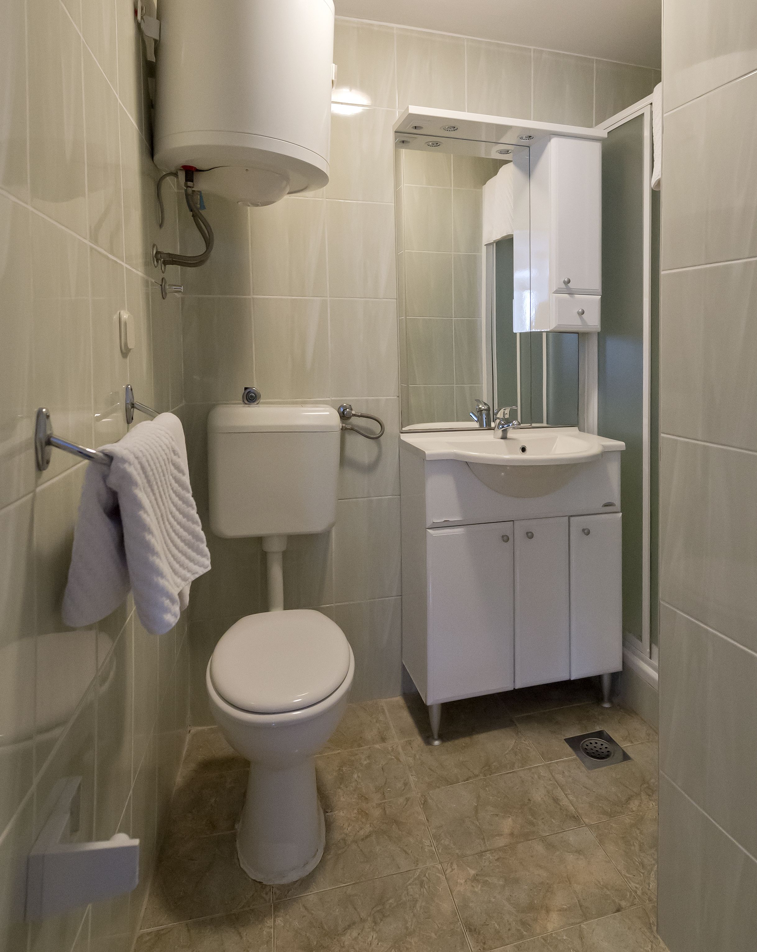 Un baño con inodoro, lavabo y espejo.