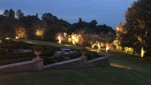 A formal garden with manicured lawns, geometric hedges, and classical architecture. - Hotel Villa Policreti (Aviano)