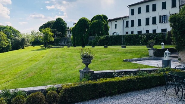 A well-maintained lawn, a classical building with multiple windows, and a clear sky. - Hotel Villa Policreti (Aviano)