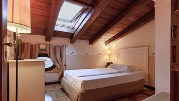 Un dormitorio con tragaluz, cama, escritorio y silla.