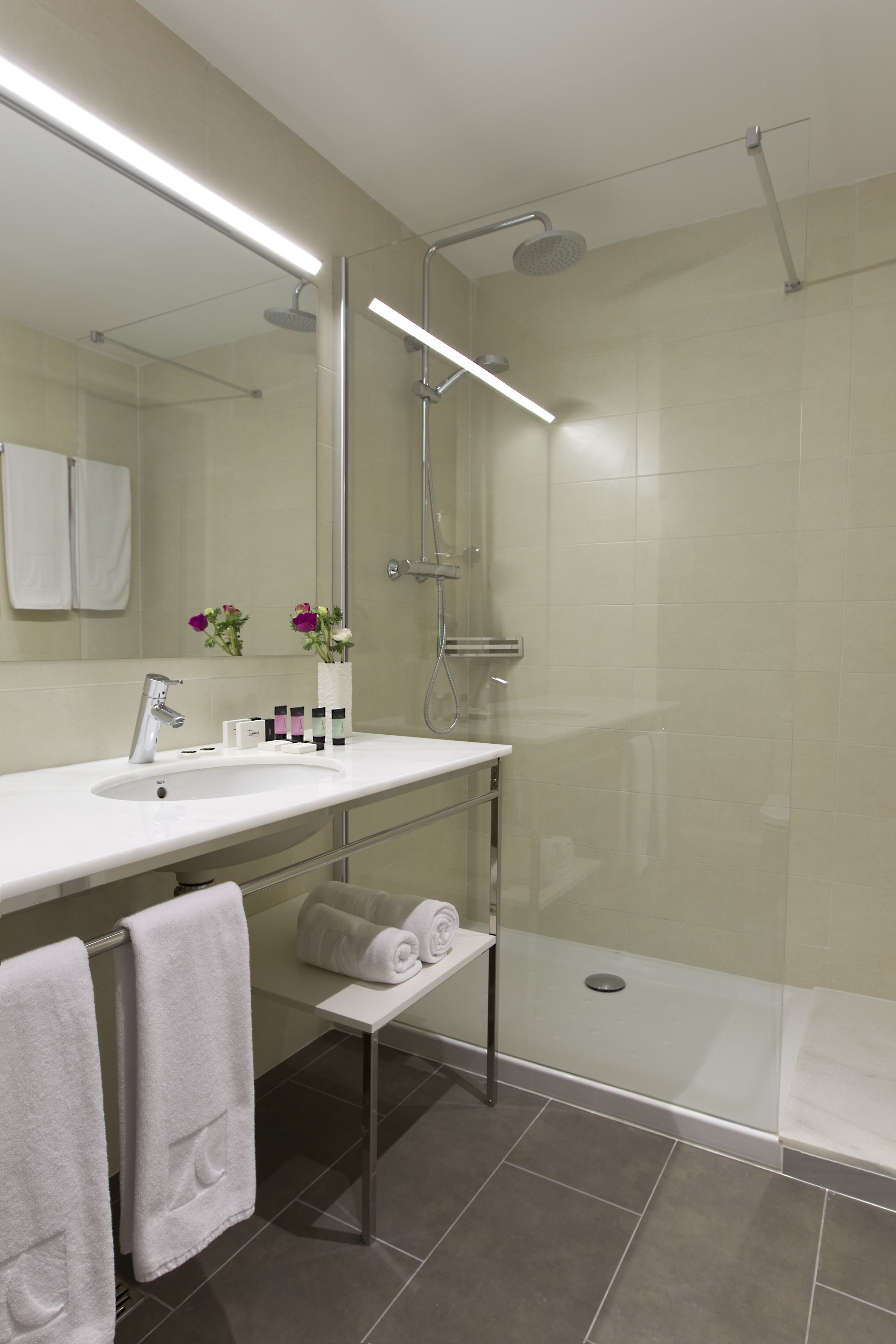 Ein modernes Badezimmer mit Dusche, Waschbecken und Spiegel.