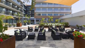A rooftop patio with outdoor seating and potted plants.