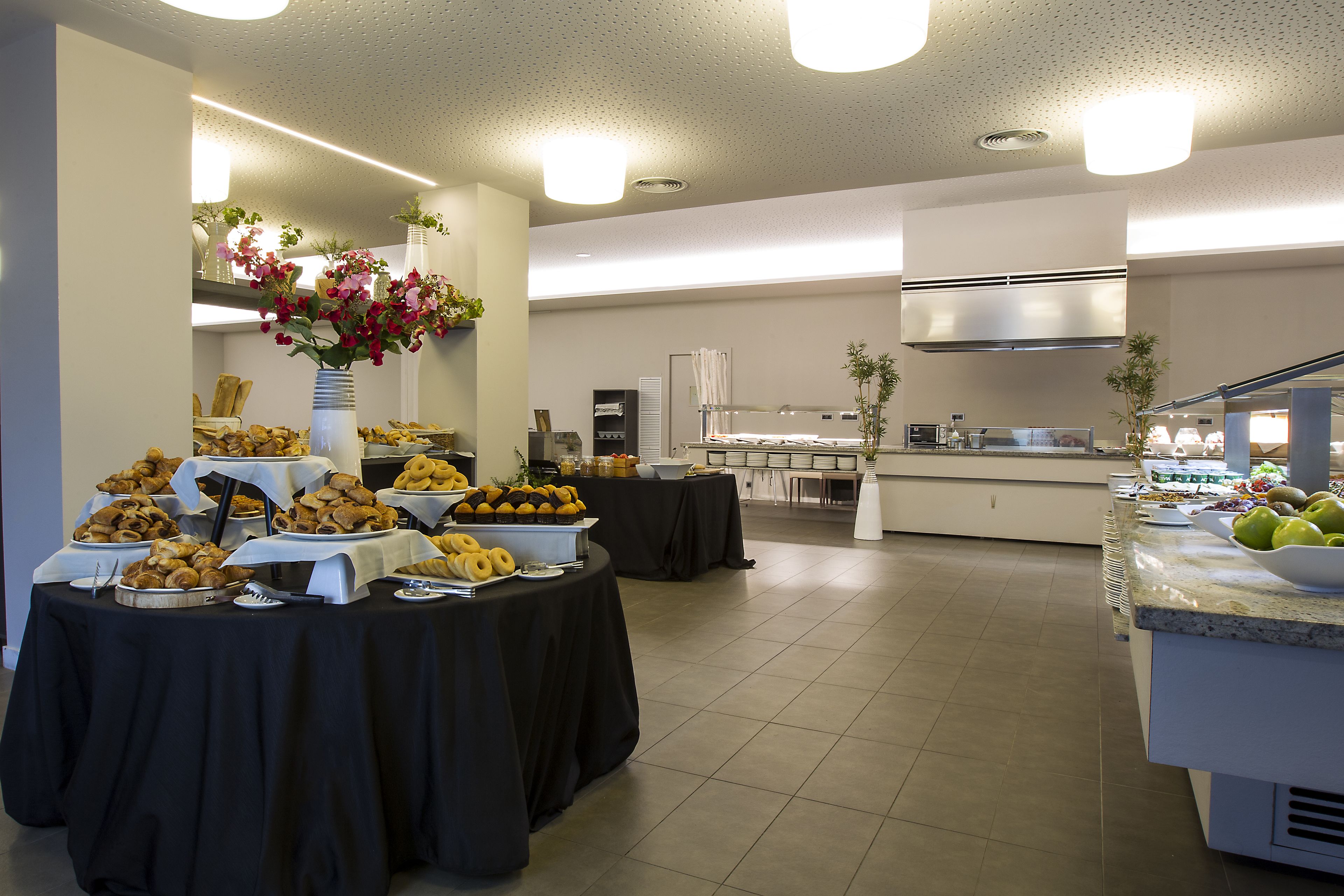 Ein reichhaltiges Buffet mit verschiedenen Speisen und einer Küche im Hintergrund.