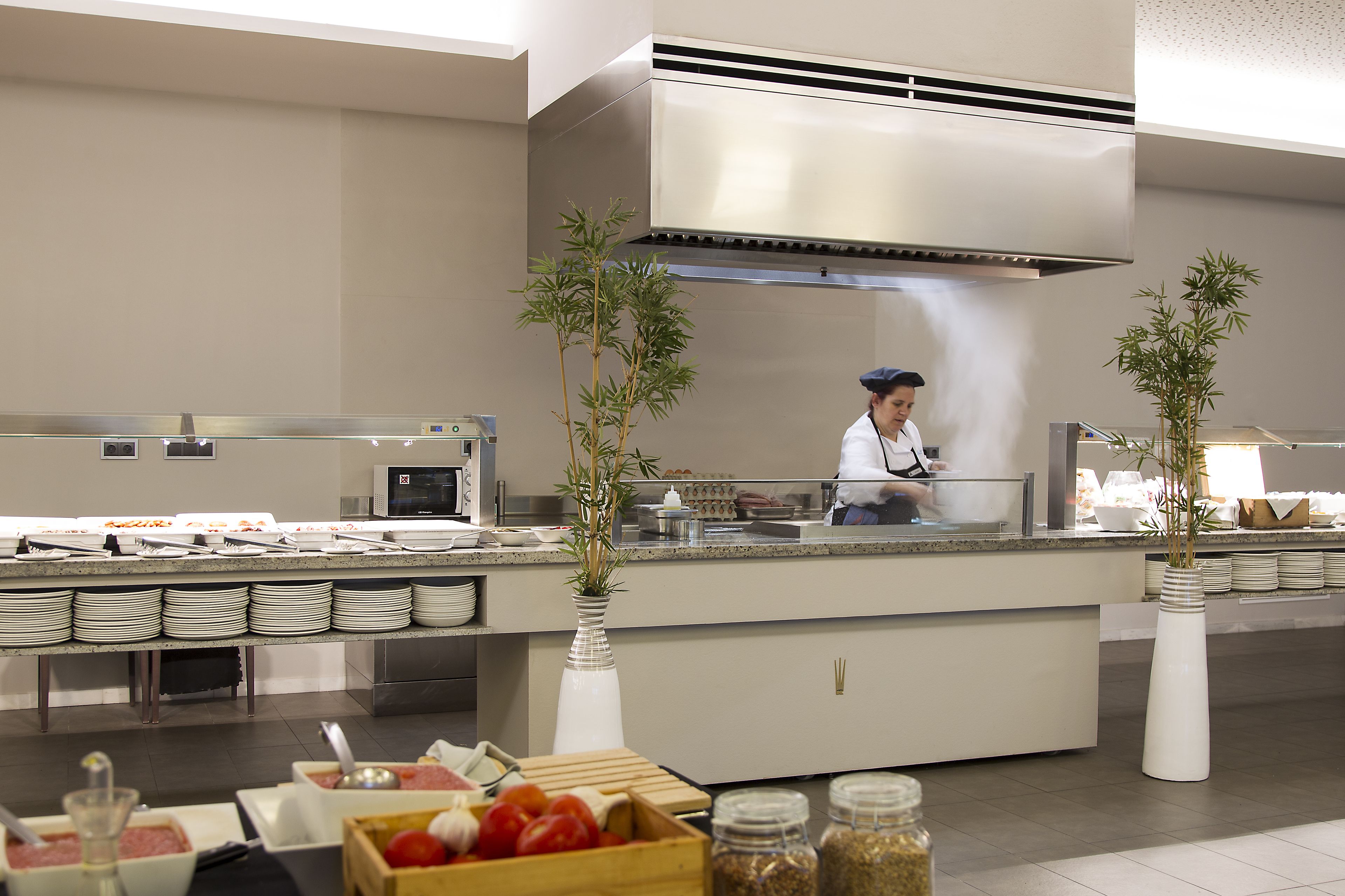 Uma mesa de buffet com diversos alimentos e um chef preparando refeições.