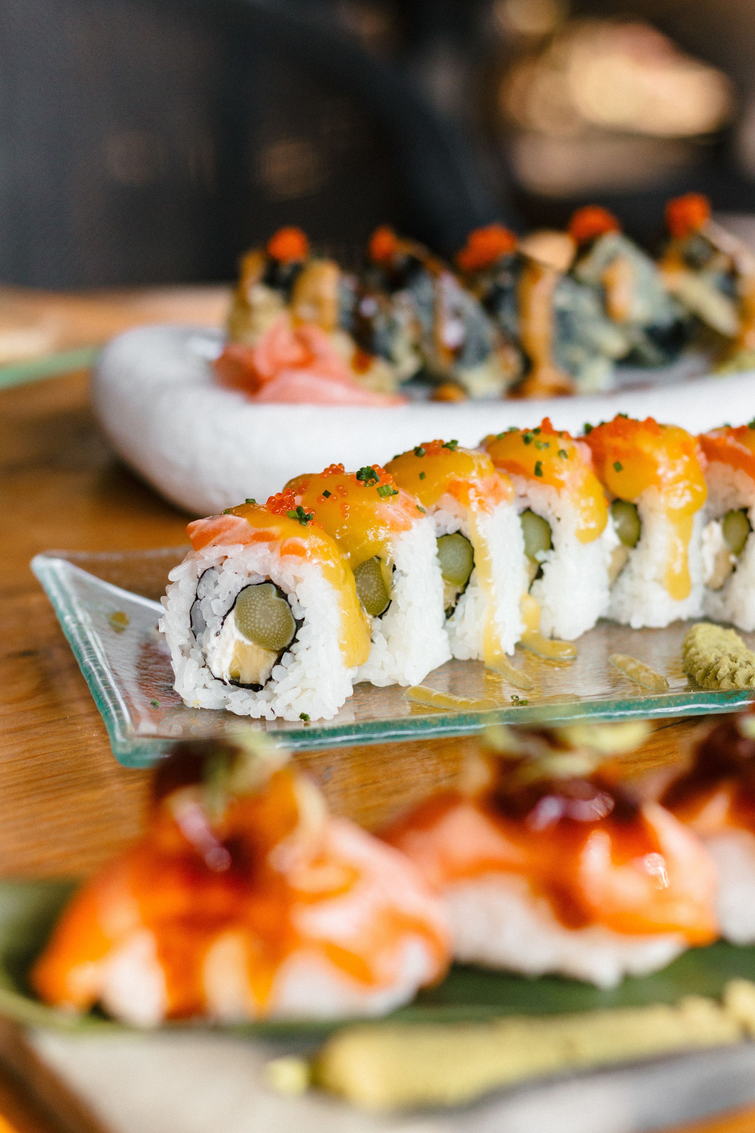 Un plateau de sushis, avec différents types de sushis, présenté sur une assiette en verre.