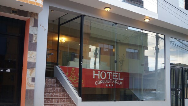 A hotel entrance with a staircase leading up to the door, a glass facade, and a sign reading "HOTEL CONQUISTADOR". - Hotel Conquistador (Andahuaylas)