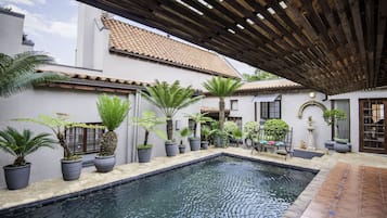 Een buitenzwembad en ligstoelen