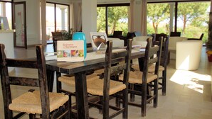 A dining area with a wooden table and chairs, a menu, and a view of the outdoors. - Hotel Tartaruga Bianca (Valledoria)