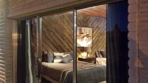 Ein Schlafzimmer mit einem Bett, Kissen, einem Nachttisch und einer Lampe.