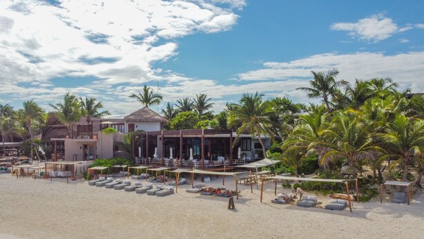 A beach resort with multiple bungalow-style accommodations, outdoor seating areas, and palm trees. - Lula Tulum, a Small Luxury Hotel (Tulum)
