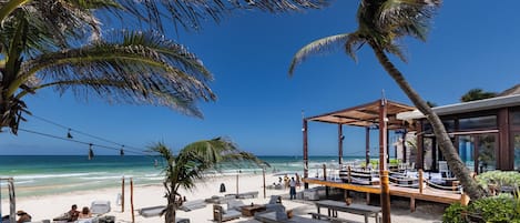 Am Strand, weißer Sandstrand, Liegestühle, Sonnenschirme
