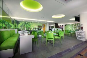 Um restaurante moderno com móveis e decoração de parede em tons de verde.