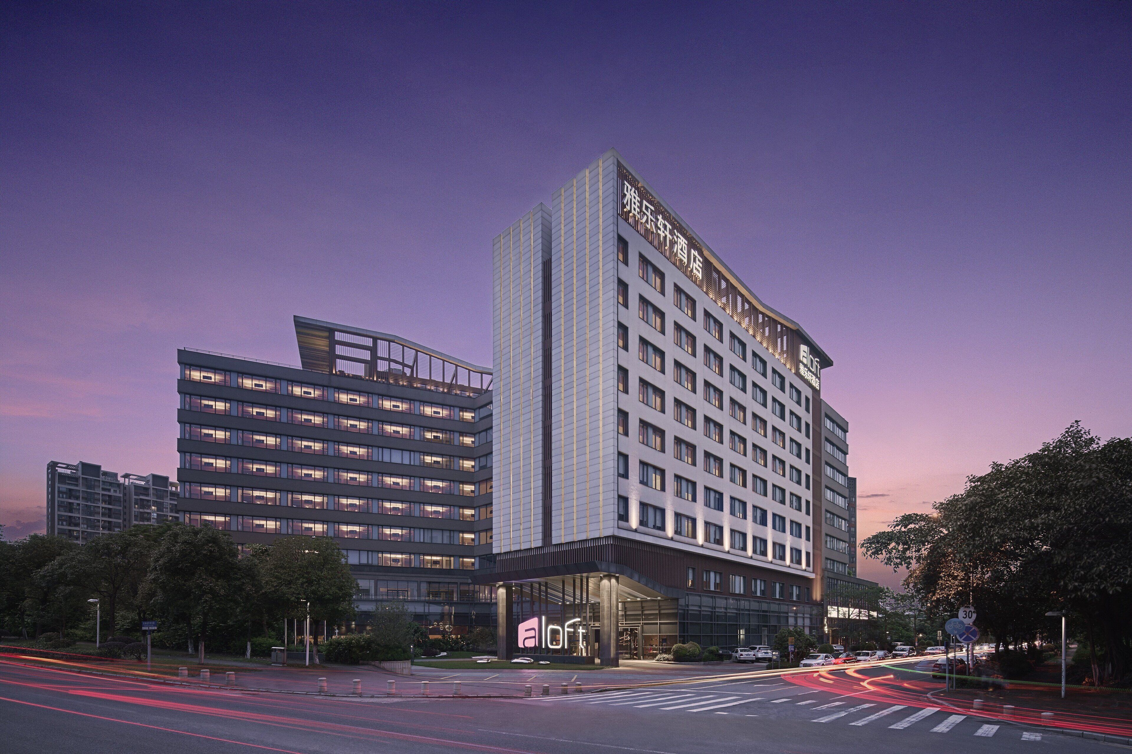 Ein modernes Hotel mit mehreren Stockwerken und einem markanten Eingang.