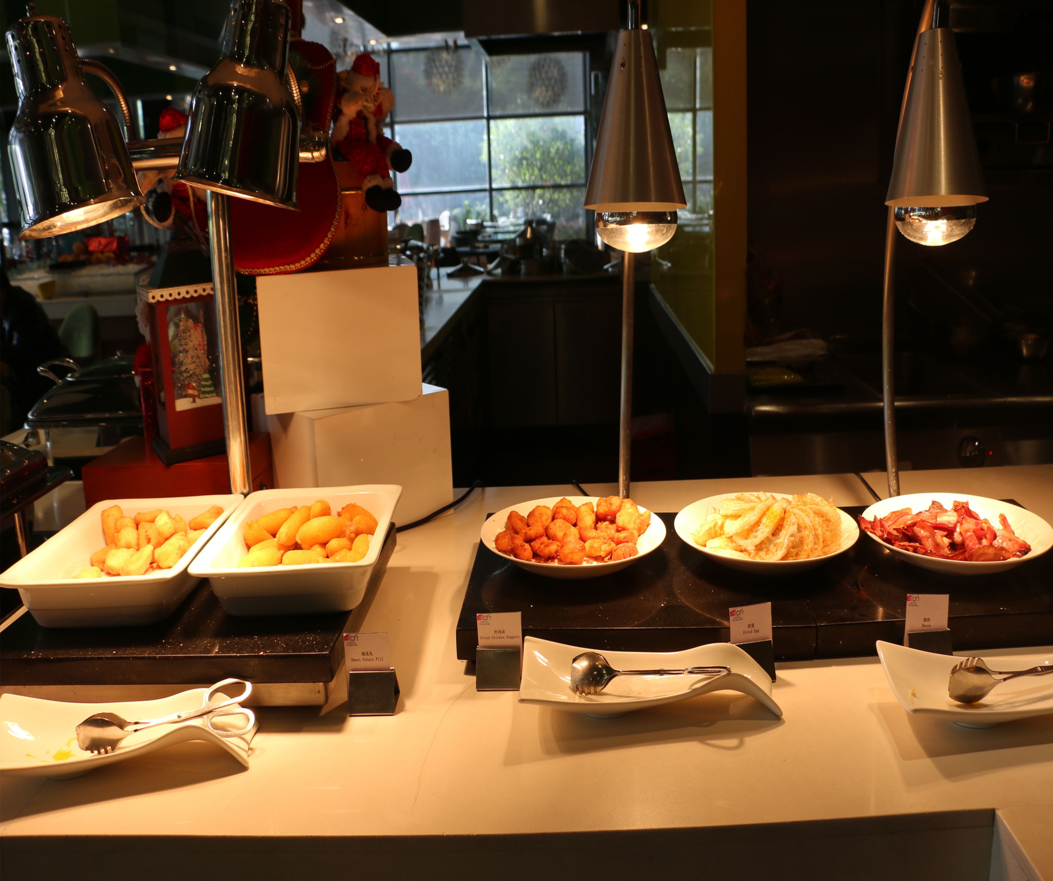 Un bufé con diversos platos y utensilios, incluyendo fuentes de comida y cucharas para servir.