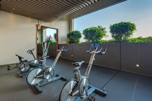 A row of stationary bikes in a modern indoor setting with a view of the cityscape. - Holiday Inn Express Hong Kong Mongkok by IHG (Kowloon)