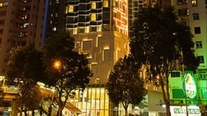 Un edificio de gran altura con varios pisos, amplias ventanas y una estructura destacada en esquina.