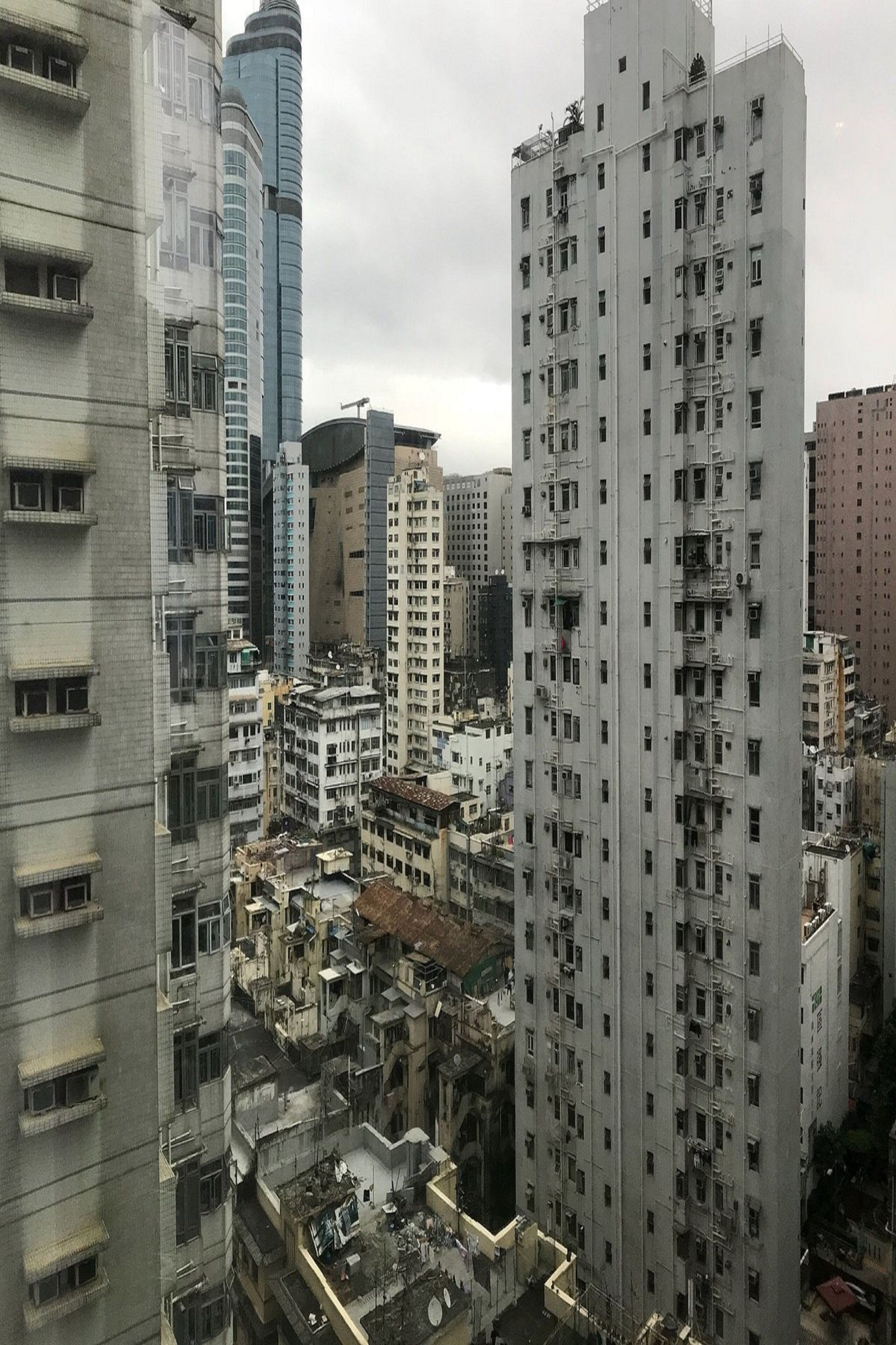 A high-rise building with multiple floors, featuring balconies and a central courtyard.