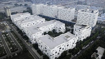 Un conjunto de edificios blancos de varios pisos con un patio central, rodeado de calles y otros edificios.