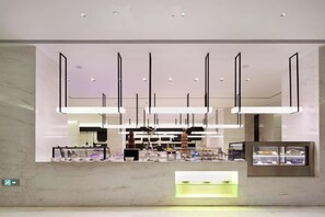 A modern hotel reception area with a marble counter, pendant lighting, and a glass display case. - Ziyuan Hotel (Wuhan)